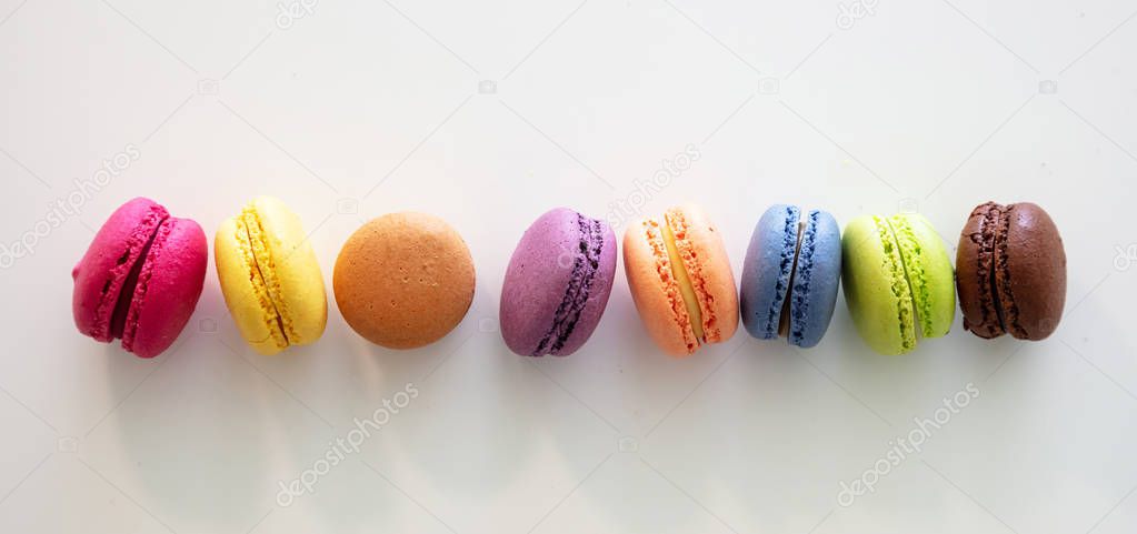 Colorful macarons on white background, close up view