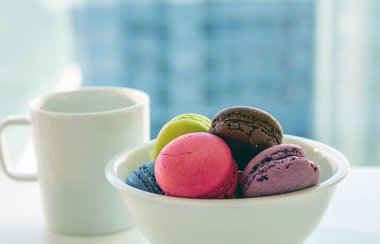 Beyaz arka planda renkli makarnalar ve kahve fincanı, yakından görünüm