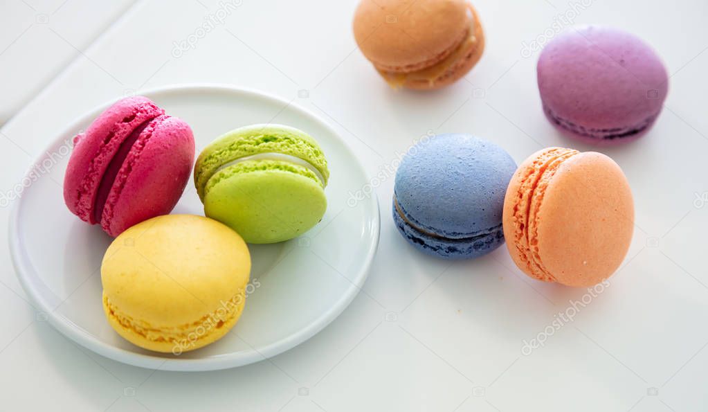 Colorful macarons on white background, close up view