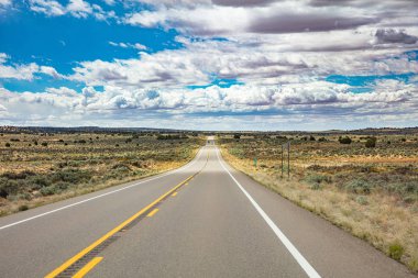 Iniş ve iniş, bulutlu mavi gökyüzü ile uzun bir otoyol. Abd