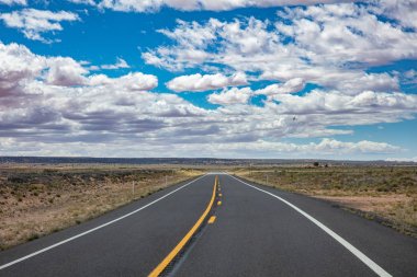 Iniş ve iniş, bulutlu mavi gökyüzü ile uzun bir otoyol. Abd