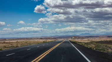 Iniş ve iniş, bulutlu mavi gökyüzü ile uzun bir otoyol. Abd