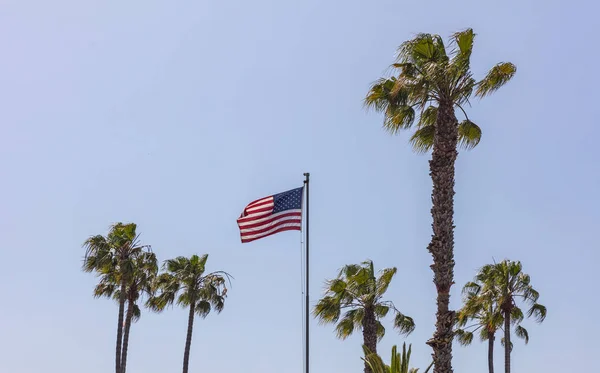 Bandeira dos Estados Unidos em um pólo acenando no fundo do céu azul . — Fotografia de Stock