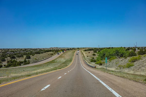Long highway in the american countryside, blue cloudy sky background — Stock Photo, Image