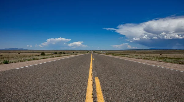Langer Highway in der amerikanischen Wüste, blauer Himmel mit Wolken — Stockfoto