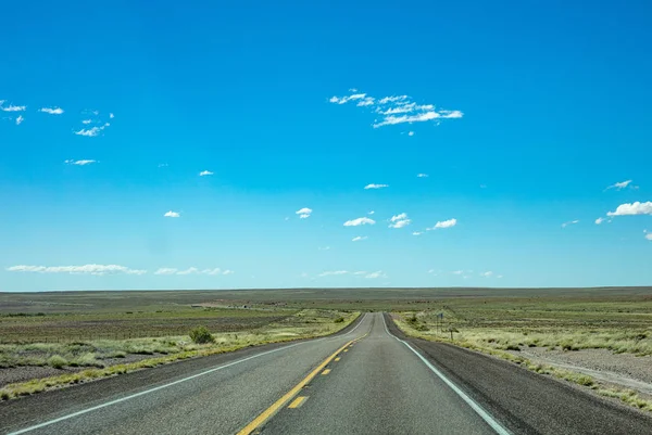 Lunga autostrada nel deserto americano, cielo blu — Foto Stock