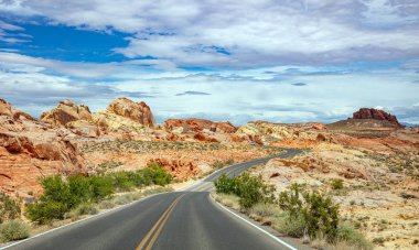 Iniş ve iniş, bulutlu mavi gökyüzü ile uzun dolambaçlı karayolu. Valley of Fire Nevada, Amerika Birleşik Devletleri