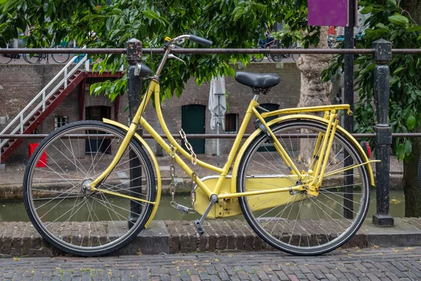네덜란드 위트레흐트 시의 강 운하 레일에 잠긴 노란색 자전거 색상 — 스톡 사진