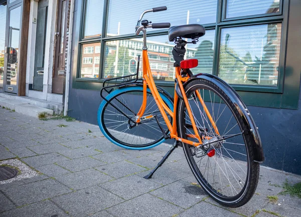 Rower pomarańczowy kolor zaparkowany na chodniku w Rotterdam City, Holandia — Zdjęcie stockowe