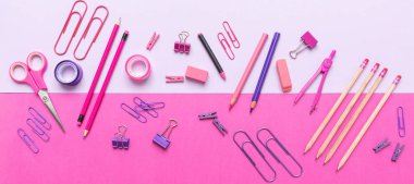 Düz ofis, pembe arka planda okul kırtasiye yatıyordu