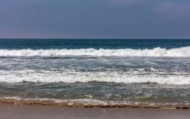 Kumlu plaj boş. Mavi gökyüzü, dalgalar ile mavi deniz