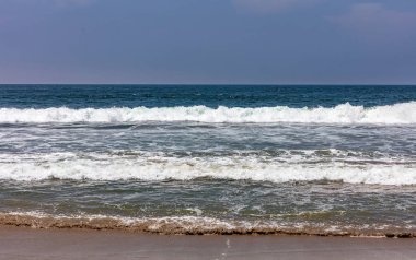 Kumlu plaj boş. Mavi gökyüzü, dalgalar ile mavi deniz