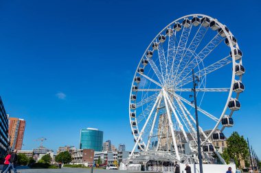 Dönme dolap ve etrafta dolaşan insanlar. Markthal Rotterdam, Hollanda.