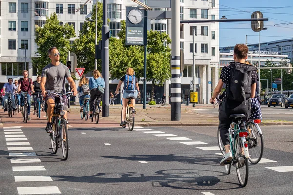 Emberek lovaglás kerékpárok a város központjában, napos tavaszi reggelen — Stock Fotó