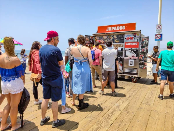 Japadog Street Food, mensen wachtrij wacht op Santa Monica houten pier, traditionele winkel voor hotdogs — Stockfoto