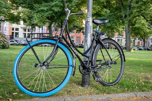 Bicicletta appoggiata su un palo metallico nella città di Rotterdam, Paesi Bassi — Foto Stock