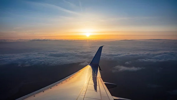 Sunrise uitzicht uit een vliegtuig venster. Vliegtuig over de wolken vliegen. — Stockfoto