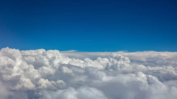 Blauer Himmel und flauschige Wolken. Blick aus dem Flugzeugfenster. — Stockfoto