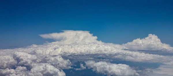 Céu azul e nuvens fofas. Vista de uma janela de avião . — Fotografia de Stock
