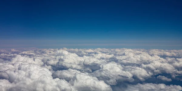 Blue sky and fluffy clouds. View out of a plane window. Royalty Free Stock Photos