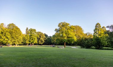 Bir şehir parkında çimüzerinde dinlenen insanlar, Rotterdam, Hollanda.