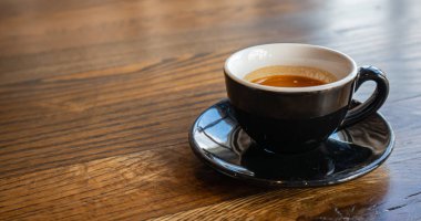 Espresso fincan, ahşap masa üzerinde tabak ile siyah renk