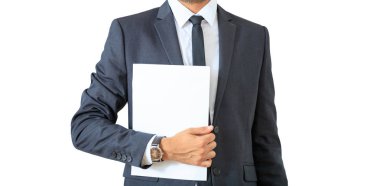 Gri takım elbiseli genç işadamı beyaz arka plan aleyhine izole kağıtları tutan.