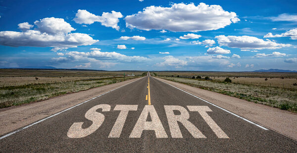 Start concept. Text sign on a long straight road, blue sky background