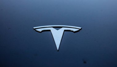 Rotterdam, Hollanda'da mavi arka plan üzerinde Gümüş Tesla işareti. Yakın çekim görünümü.