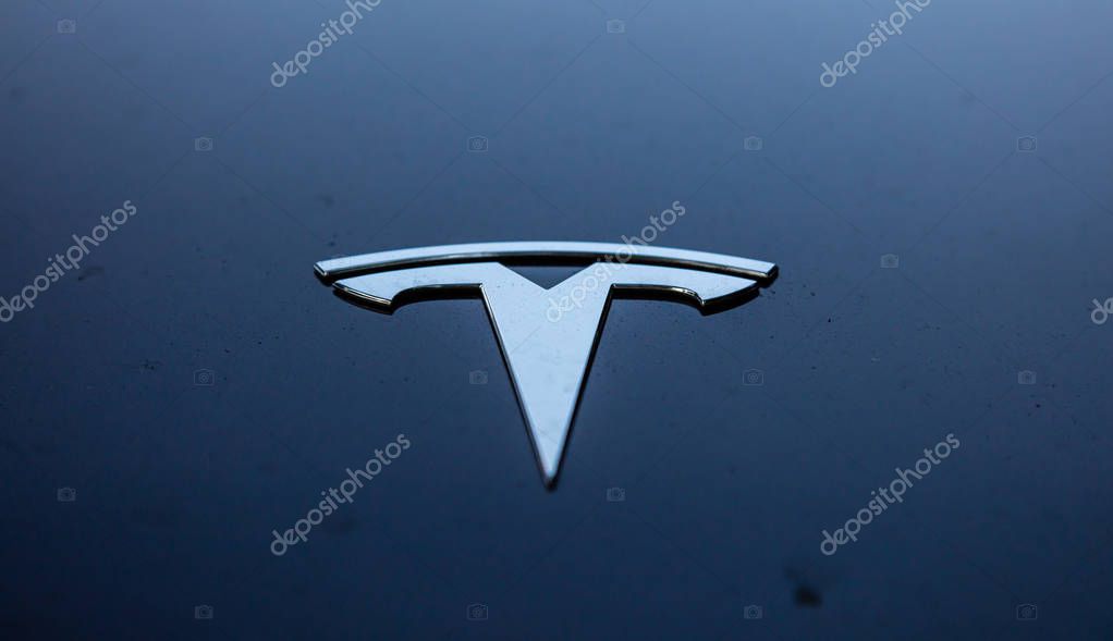 Rotterdam, Netherlands. June 29, 2019. Silver sign of Tesla automotive and energy company on blue background. An ecological, luxury and fast car.