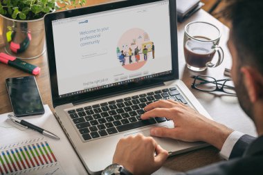 Bir bilgisayarla çalışan yönetici, ekranda Linkedin sayfası