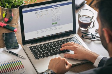 Bir bilgisayarla çalışan yönetici, ekranda Facebook sayfası