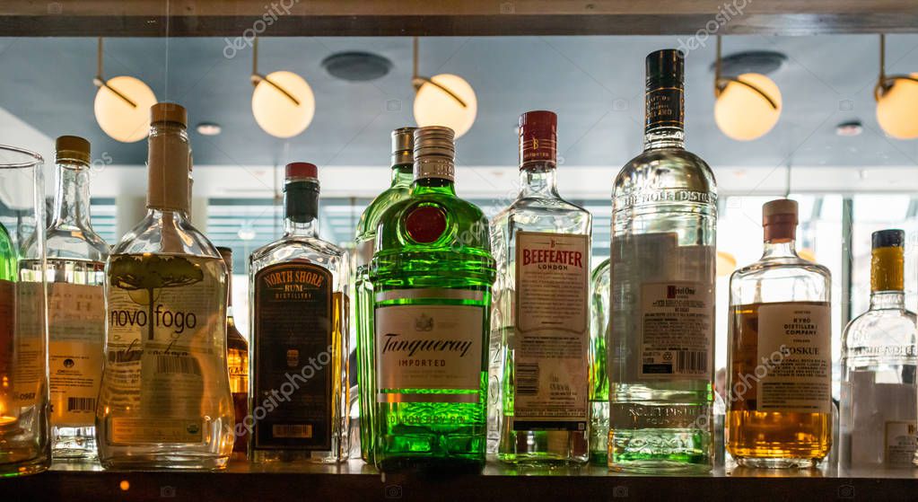 Chicago, Illinois USA. May 9, 2019. Close-up view of alcohol bottles brands on a shelf in front of a mirror. Hotel bar downtown
