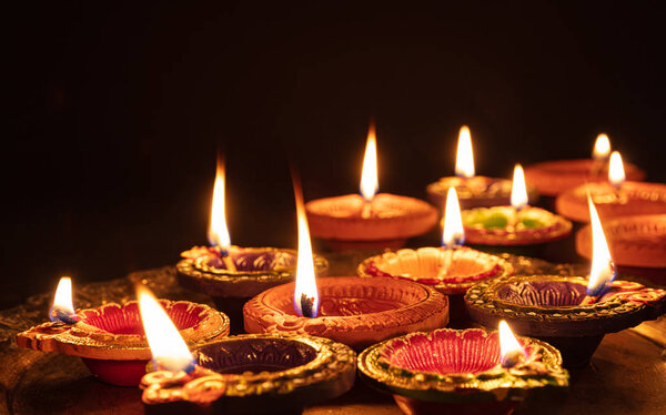 Diwali, Hindu festival of lights celebration. Diya oil lamps against dark background,