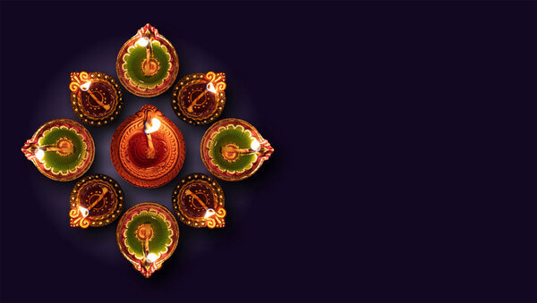 Happy Diwali. Diya oil lamps against dark background,