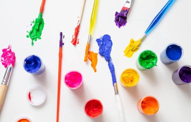 Beyaz arkaplan üzerine ayarlanmış renkli parmak boyaları, üst görünüm