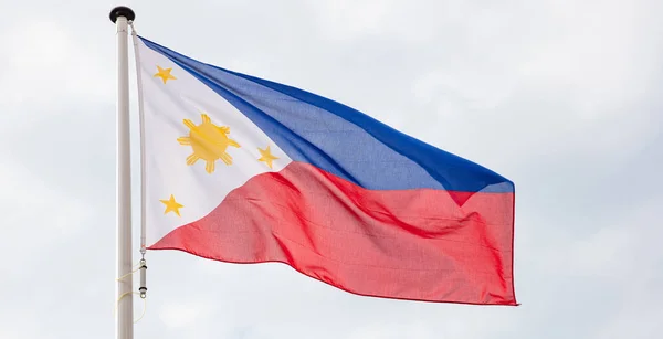 Bandeira das Filipinas acenando contra fundo céu nublado — Fotografia de Stock