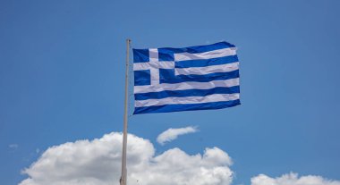 Yunanistan 'ın işareti. Bayrak direğindeki Yunan bayrağı rüzgarda dalgalanıyor. Mavi gökyüzü, Atina 'da güneşli bir bahar günü.