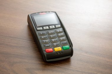 POS terminali ahşap arka planda izole edildi, kopyala alanı. Kredi kartıyla ulaşılamayan ödemeler için terminal yazar kasası. Banka ekipmanları, NFC.