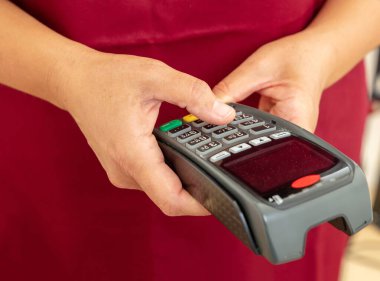 Ödeme makinesi ve daktilo makinesi tutan adam, yakın çekim. Kredi kartı okuyucu, POS terminal ödeme kavramı.