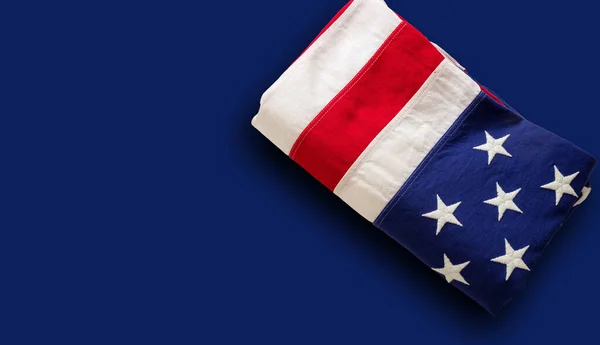 アメリカ国旗が青い背景に折り畳まれている アメリカの旗のトップビュー コピースペース 記念の日と7月4日独立記念日の概念 カード ポスターテンプレート — ストック写真