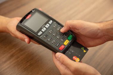 Atina, Yunanistan. 27 Haziran 2020. Kablosuz POS ödeme terminali Ingenico kredi kartı ile Mastercard beyaz arka planda izole, görünümü kapatın.