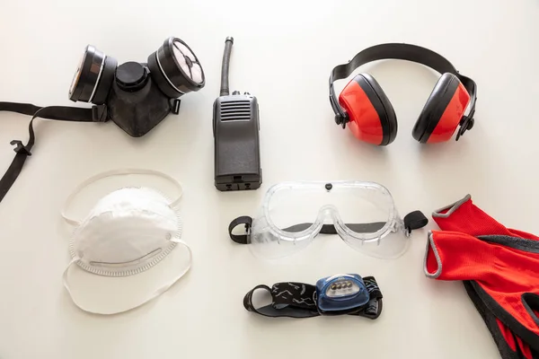 Work safety protection equipment flat lay. Industrial protective gear on white background. Construction site health and safety concept.