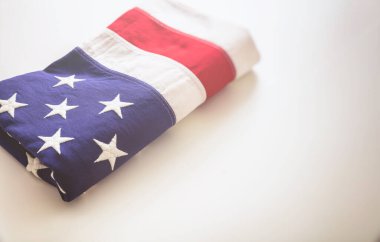 Amerikan bayrağı beyaz arka planda katlandı. Amerikan bayrağı yakın çekim görüntüsü, kopyalama alanı. Anma günü ve 4 Temmuz, Bağımsızlık Günü konsepti. Kart, poster şablonu