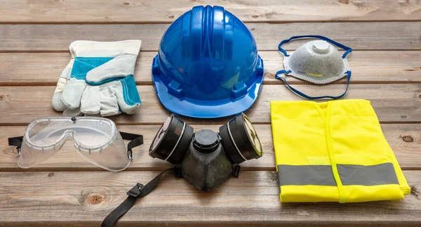 Work safety protection equipment. Industrial protective gear on wooden background. Construction site health and safety concept