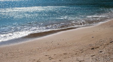 Kumsal, sahilde dalgalar, deniz suyundaki yansımalar, sabahın erken saatlerinde plaj arkaplanı boş..