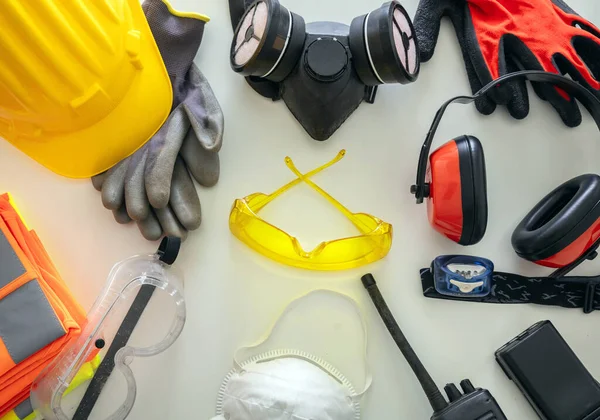 Work safety protection equipment flat lay. Industrial protective gear on white background, top view. Construction site health and safety concept