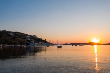 Kea Tzia Adası, Cyclades, Yunanistan. Gün batımında Vourkari marinası. Yelkenliler ve gökyüzü, sakin suya yansıyor