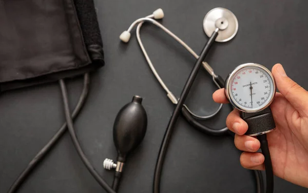 Vérnyomásmérés Kézfogás Egy Vérnyomásmérő Műszer Fekete Színű Háttér Közelkép — Stock Fotó