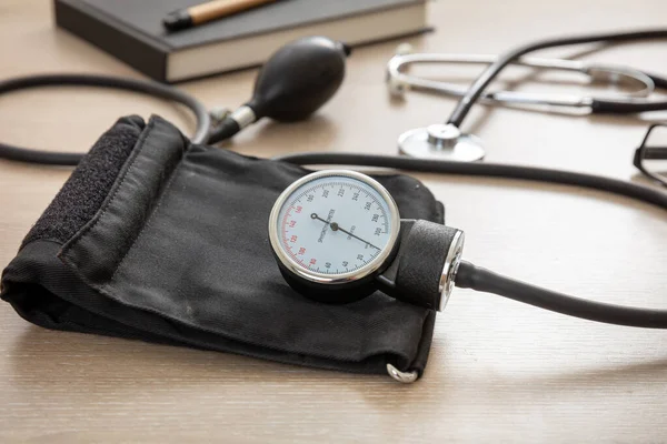 血圧計 高血圧制御 医療用聴診器と医師室のデスクのSphygmomanometer クローズアップビュー — ストック写真